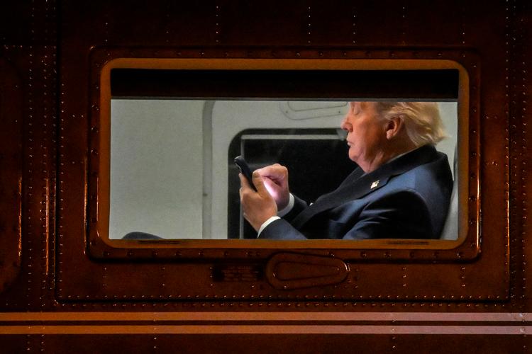 Donald Trump fifler lidt med mobile om bord på præsidenthelikopteren Marine One. Foto: Alex Wroblewski/Ritzau Scanpix