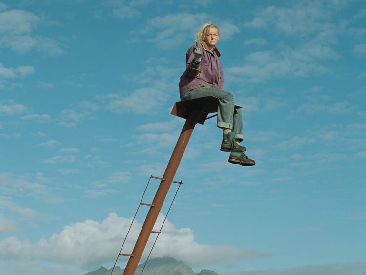 Saga Garðarsdóttir spiller kunstneren Anna, der kæmper for at få udstillet sin kunst, som hun laver i den islandske natur. Hun er den, der er bedst til at se tingene oppefra i den kriseramte familie. Her sidder hun i et aggregat, som instruktøren Hlynur Pálmason byggede i forbindelse med en tidligere film 'Vanskabte land'.  
credit: Scanbox Foto: Still fra film