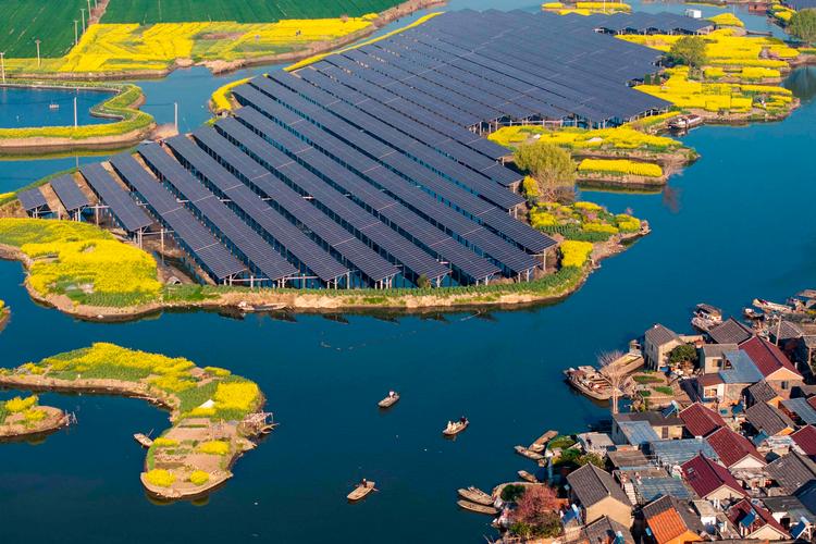 Ved byen Taizhou i Kinas østlige Jiangsu-provins ses en solcellepark ved siden af de gule rapsmarker. Kina satser stort på blandet andet energi fra solceller.    Foto: -/Ritzau Scanpix