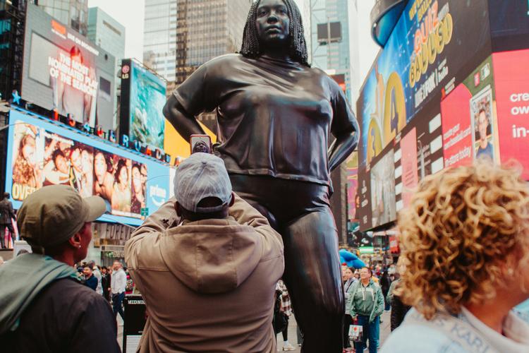 Folk står i kø for at fotografere skulpturen 'Grounded in the Stars', som er opstillet på Times Square midt i New York fra 29. april til 14. juni. Mange kritikere har dog opfordret til, at statuen bliver fjernet før tid. Foto: Sebastian Skov Andersen