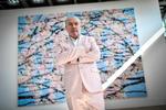 Damien Hirst poserer foran et af sine værker i 2021. For nylig offentliggjorde han sit seneste projekt – 200 notesbøger med værker, som kan produceres 200 år efter hans død. Foto: Stephane De Sakutin/Ritzau Scanpix