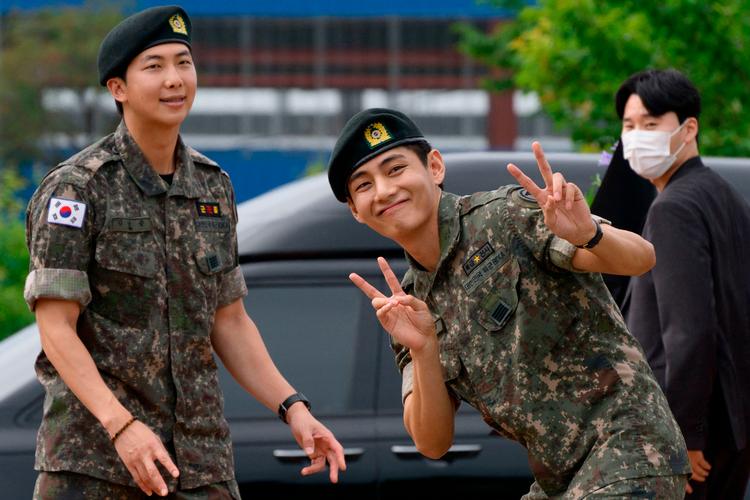 RM (til venstre) og V poserer for fotografer efter afslutningen på 18 måneder i militæret.  Foto: Shin Yong-ju/Ritzau Scanpix