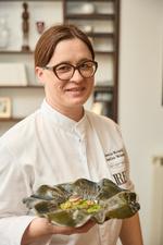 Ksenija Mahorčič præsenterer sin færdige tallerken med mad på om aftenen i restauranten. 
