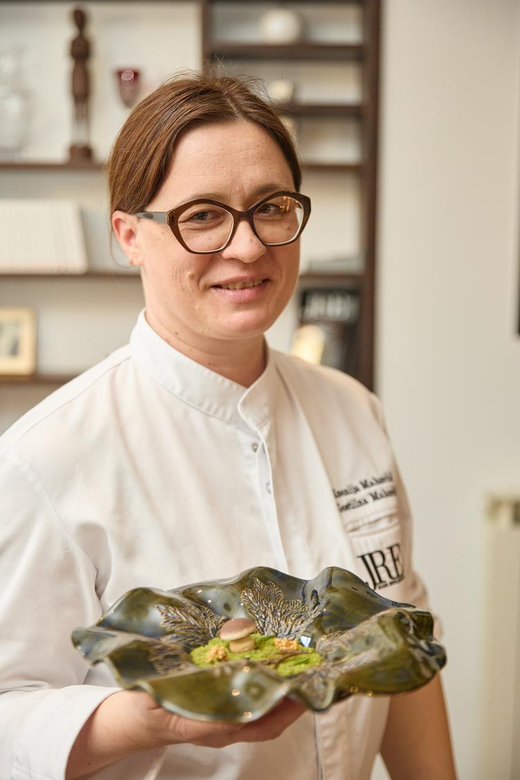 Ksenija Mahorčič præsenterer sin færdige tallerken med mad på om aftenen i restauranten. 
