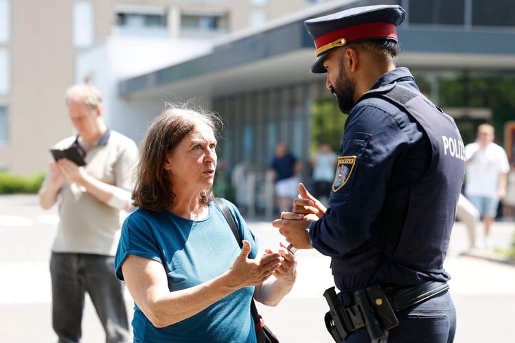 Borgmester i Graz, Elke Kahr i samtale med politimand ved skolen, hvor skyderierne er foregået.   Foto: Erwin Scheriau/Ritzau Scanpix