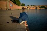 En mand bruger en paraply til at søge ly ved Garonne-floden i Toulouse i det sydlige Frankrig. Landet blev i år ramt af en tidlig hedebølge, hvilket fik myndighederne til at udstede en hedebølgeadvarsel, der begyndte 20. juni i 16 departementer i Frankrig. Foto: Ed Jones/Ritzau Scanpix