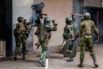 En demonstrant hopper i sikkerhed ud fra en smal allé, mens betjente slår hende med pisk og køller i Nairobi.  Foto: Luis Tato/Ritzau Scanpix