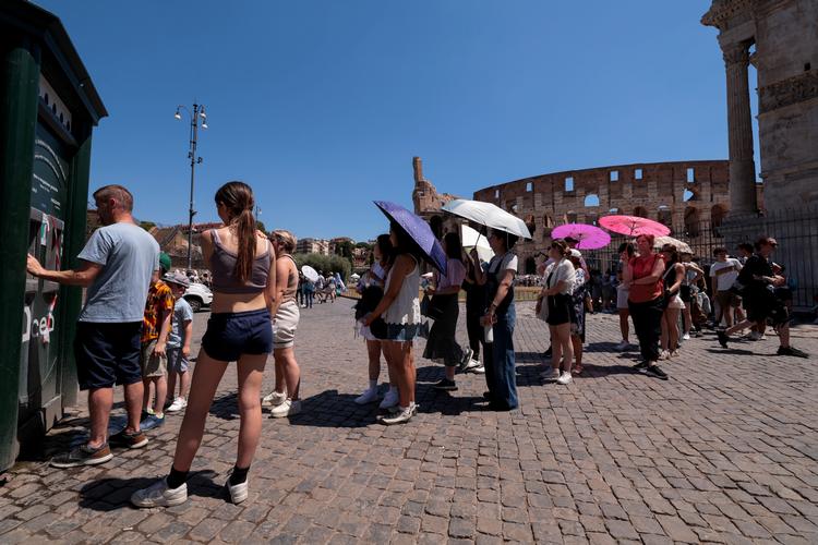 Turister står i kø i Grækenlands hovedstad, Athen, for at få noget vand at køle sig ned med. Foto: Remo Casilli/Ritzau Scanpix