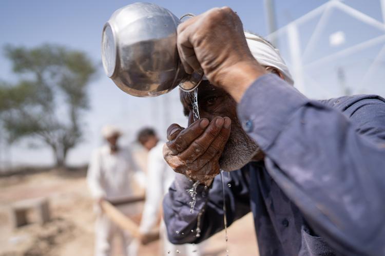 En murerarbejdsmand tager en drikkepause Rajasthan i Indien, hvor temperaturen på denne tid af året kan overstige 40 grader. 
 Foto: Anindito Mukherjee/Ritzau Scanpix