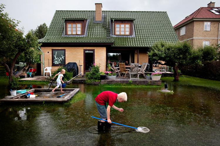 Den meteorologiske definition på et skybrud er, ifølge Danmarks Meteorologiske Institut (DMI), at der falder mere end 15 mm nedbør på 30 minutter. Men det er de fiskende børn på græsplænen nok ret ligeglade med. Arkivfoto:  Miriam Dalsgaard