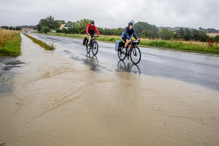 Cykelstien er blevet til et vandløb på Møn, hvor der faldt 160 mm vand tirsdag. Et vildt tal, for gennemsnittet for en hel juli måned er 65 mm. Foto: Ingrid Riis/Ritzau Scanpix
