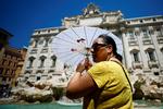 En kvinde søger skygge under en parasol ved Trevi-fontænen i Rom under en hedebølge for to siden. Ifølge journalsiten og forfatteren David Broder er Europas grønne vilje ved at smuldre. Foto: Guglielmo Mangiapane/Ritzau Scanpix