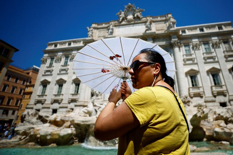 En kvinde søger skygge under en parasol ved Trevi-fontænen i Rom under en hedebølge for to siden. Ifølge journalsiten og forfatteren David Broder er Europas grønne vilje ved at smuldre. Foto: Guglielmo Mangiapane/Ritzau Scanpix