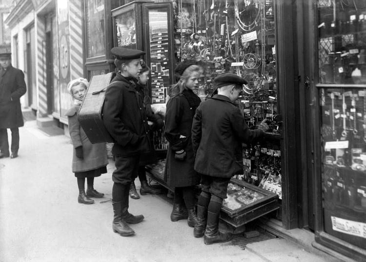 En flok børn stirrer tryllebundet på en vinduesudstilling på Gl. Kongevej på Frederiksberg. Fotoet var Politikens første publicerede pressefotografi, taget af Holger Damgaard i 1908. Foto: Holger Damgaard