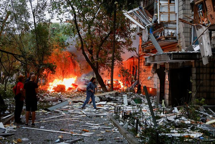Beboere betragter ødelæggelserne efter at en boligblok i Kyiv natten til torsdag blev ramt af et russisk missil og droner.     Foto: Valentyn Ogirenko/Ritzau Scanpix