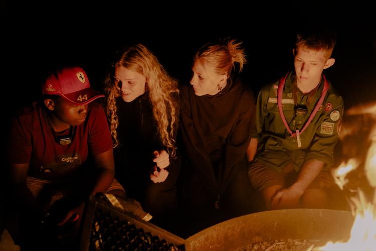 Rundt om bålet lægger eleverne en plan for de kommende dage. De taler også om, hvor mange der allerede har fået en kæreste på efterskolen.  Foto: Peter Maunsbach