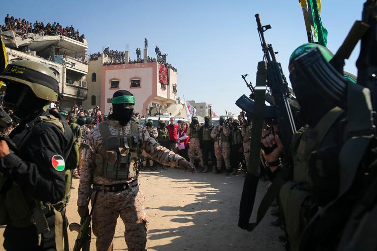 Hamas- og Islamisk Jihad-militante sikrer området, mens repræsentanter fra Røde Kors venter på overdragelsen af gidsler i Khan Younis i det sydlige Gaza i januar. Foto: Jehad Alshrafi/Ritzau Scanpix