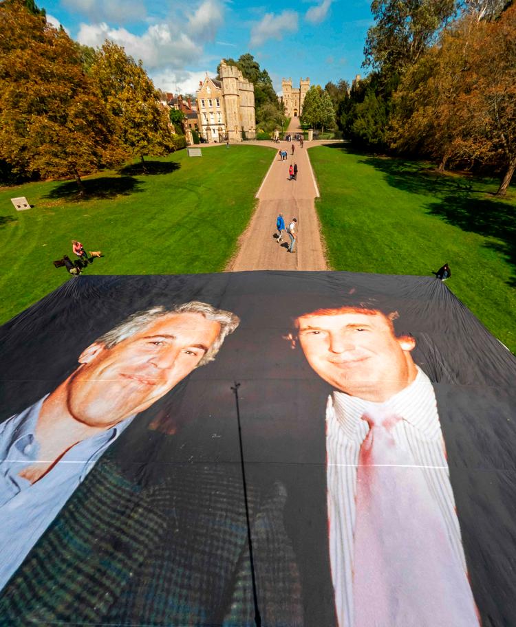Aktivister folder et stort foto ud, der forestiller den amerikanske præsident Donald Trump poserer med Jeffrey Epstein foran Windsor Castle i forud for statsbesøget af den amerikanske præsident.  Foto: -/Ritzau Scanpix