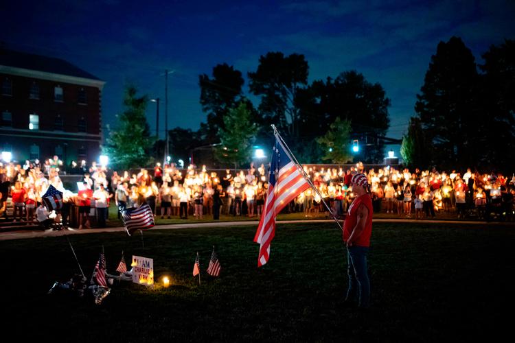 En mand holder et flag under en mindehøjtidelighed for Charlie Kirk i Kentucky onsdag.    Foto: Jon Cherry/Ritzau Scanpix