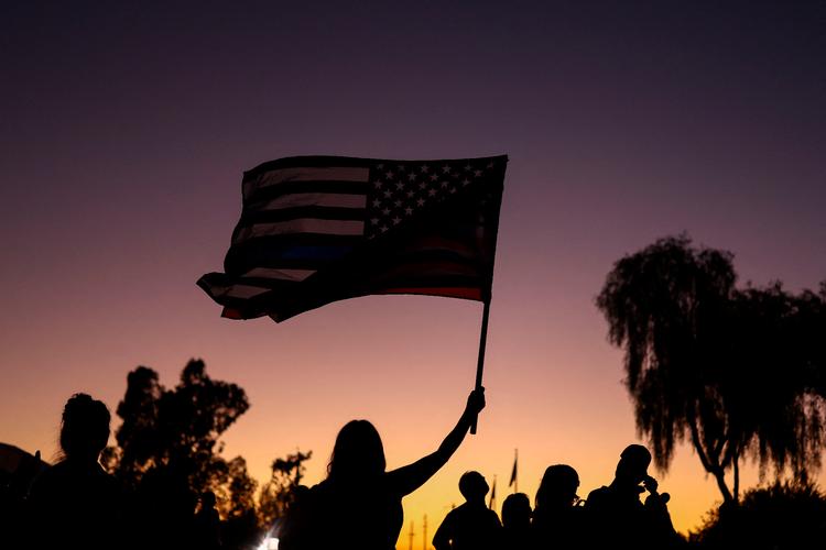 Det amerikanske flag vejrer i skumringen. Ifølge journalist M. Gessen er den amerikanske regering godt i gang med at ændrer den daglige fysiske, økonomiske og psykiske oplevelse af livet.  Foto: Charly Triballeau/Ritzau Scanpix