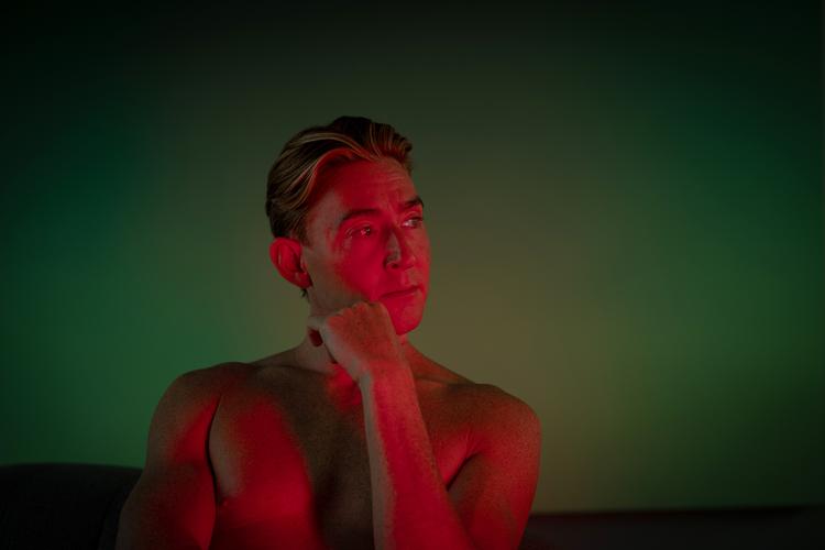 Når Emil Thorup hver dag sidder foran sit lyspanel til 20 minutters red light therapy, er der så meget lys, at han ikke kan lave noget imens – og det får ham faktisk til at sidde stille. En disciplin, han ellers kan have svært ved i det daglige. Foto: Miriam Dalsgaard