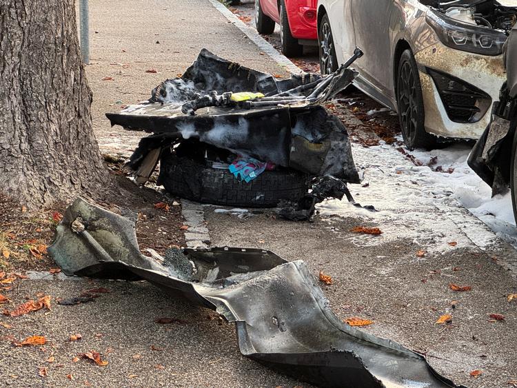 Dele af en ødelagt bil ligger ved siden af vejen, efter at politi og brandvæsen mødte talstærkt op i Lerchenauer Strasse i det nordlige München i kølvandet på meldinger om eksplosioner og skud. Foto: Ayhan Uyanik/Ritzau Scanpix