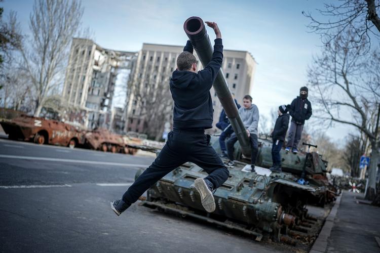 Børn leger på en ødelagt russisk tank ved det tidligere regionskontor for Mykolajiv-området. 29. marts 2022 blev bygningen ramt af russiske missiler og næsten fuldstændig ødelagt. Arkivfoto: Kay Nietfeld
