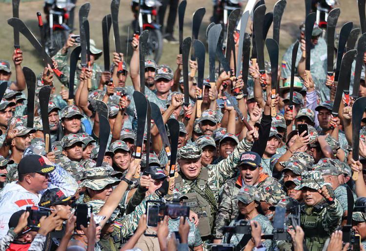 Venezuela har bevæbnet mange civile militser i lyset af, hvad landets regering ser som en nært forestående invasion fra USA. Indenrigs- og justitsminister Diosdado Cabello (nederst til højre) står her med hævet machete midt i en peptalk til Den Bolivarske Bondehær, der har sværget troskab til præsident Nicolas Maduros socialistiske revolution. Foto: Venezuelas indenrigs- og justitsministerium via Reuters  Foto: Venezuela's Interior and Justice/Ritzau Scanpix