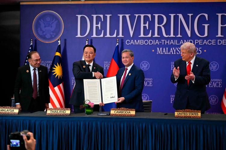 Thailands premierminister, Anutin Charnvirakul, og Cambodjas premierminister, Hun Manet, viser den underskrevne aftale, mens Donald Trump klapper. Foto: Andrew Caballero-reynolds/Ritzau Scanpix