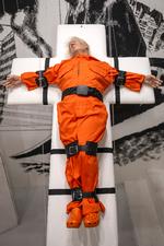 Med lukkede øjne og lidt mere rolig frisure end normalt ligger Donald Trump fastspændt på et kors af bænke som før en henrettelse i et amerikansk fængsel på galleriet Gleis 4 i Basel. Foto: Georgios Kefalas/Ritzau Scanpix