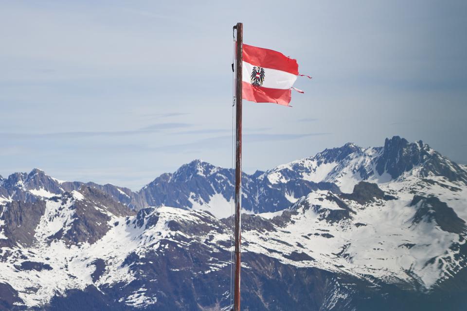 Den østrigske statsflag med rigsvåben blafrer let i den lune forårsvind. I Montafon begynder skisæsonen første weekend i december – eller så snart der er sne. De sidste skiområder lukker typisk ned i slutningen af april. Foto: Alexander Vissing