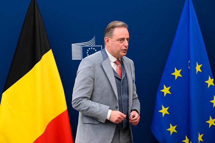 Belgiens notorisk velklædte og veltalende ministerpræsident Bart de Wever er presset af EU og egen regeringskrise. Her ses han ved siden af det flag, han ikke rigtig bryder sig om –  og det er ikke EU-flaget. Foto: Nicolas Tucat/Ritzau Scanpix