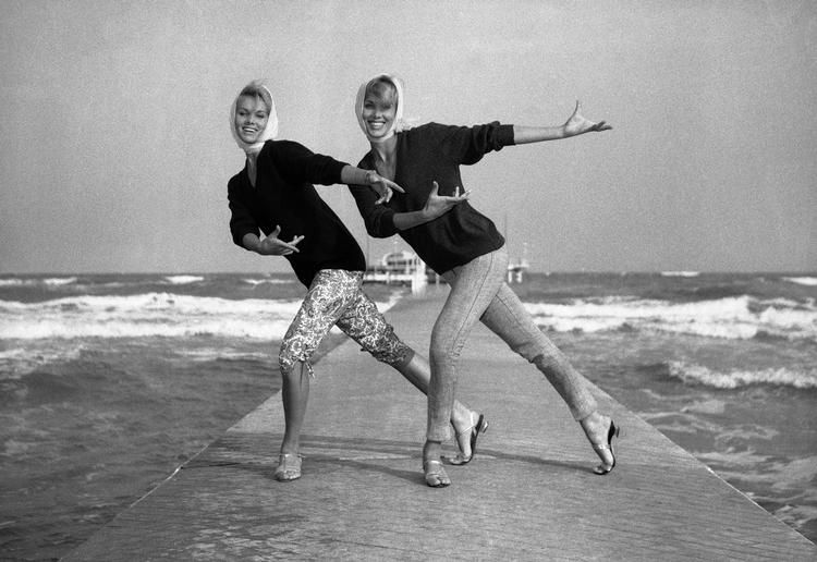 De tyske tvillingedansere Ellen (tv.) og Alice Kessler var til filmfestivalen i Venedig i 1961, hvor de viste et nyt dansetrin på stranden ved Excelsior Hotel på Lidoen. Foto: Gerolamo Di Majo/Ritzau Scanpix