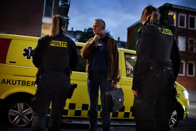 Hans Henrik Ockelmann er en af de psykiatere, som har vagter i den psykiatriske udrykningstjeneste i Region Hovedstaden. Her taler han med to betjente under en opgave i København. Arkivfoto:  Martin Lehmann
