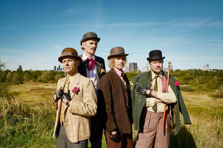 Bandet Hugorm (fra venstre: Simon Kvamm, Morten Gorm og Árni Bergmann) har sammen med sanger og musiker Peter Sommer (th.) udgivet nummeret 'Hugorm nedlægger forsvaret’. På pressefotografierne har de til lejligheden klædt sig i 'vagabond-core', som de kalder det.  Foto: Sofie Barfod/Pr/Hugorm