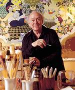 Bjørn Wiinblad i sit atelier foran et karakteristisk værk med ornamentik, mønstre og stiliserede mennesker og dyr.  Foto: Bjørn Wiinblads Fond