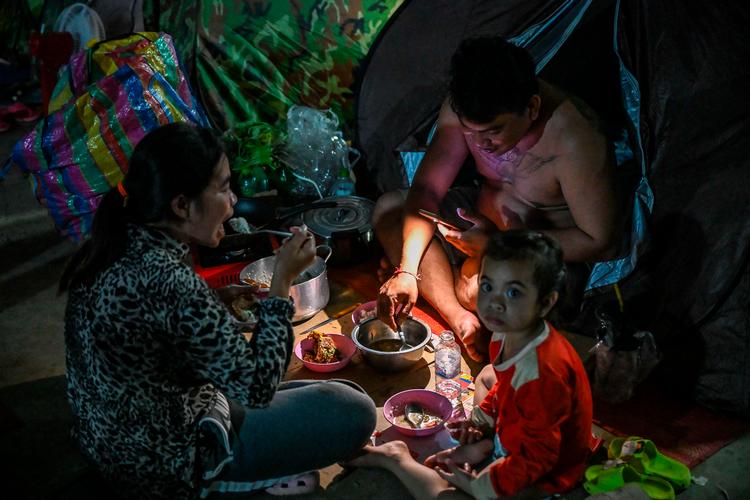 En familie på flugt får et måltid i en midlertidig lejr i Banteay Meanchey-provinsen på grænsen mellem Cambodja og Thailand.  Foto: Tang Chhin Sothy/Ritzau Scanpix
