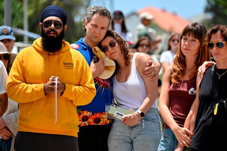 Australiere sørger mandag foran pavillonen ved Bondi strand, der ligger ved Sydney. Foto: Saeed Khan/Ritzau Scanpix