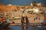 Palæstinensere kører på en æselvogn forbi bygninger og ødelagte hjem i Nuseirat i Gaza-striben. Mindst 16 mennesker døde af kulde under en vinterstorm forleden. Kraftig regn fra stormen Byron oversvømmede telte og midlertidige beskyttelsesrum over hele Gaza.   Foto: Eyad Baba/Ritzau Scanpix