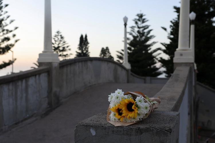 Blomster ligger på den gangbro, hvorfra gerningsmændene skød, inden de selv blev ramt af politiets skud. Området for masseskyderiet blev torsdag åbnet fop offentligheden. Foto: Hollie Adams/Ritzau Scanpix