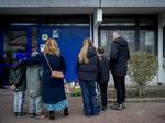Katrine Dichmann Christoffersen (nr. 3 fra venstre) lægger med sin familie blomster ved den sørgeplads, som er opstået foran opgangen i Høje Gladsaxe, hvor den dræbte toårige dreng boede med sin familie. Foto: Mads Nissen