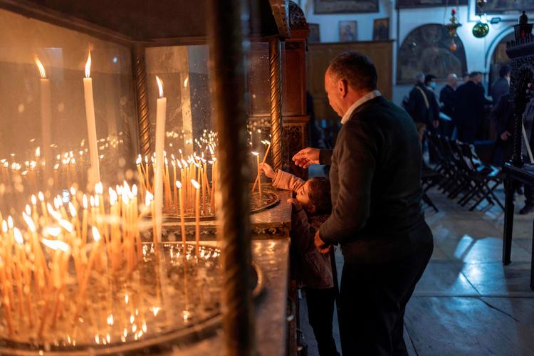 Pilgrimme og lokale kristne tænder lys i Fødselskirken, der menes at være bygget oven på Jesu fødested. Foto: Ilia Yefimovich/Ritzau Scanpix