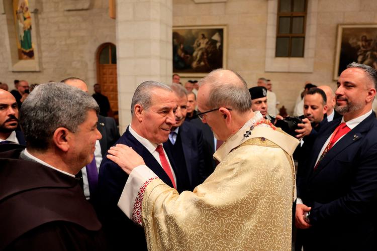 Den palæstinensiske vicepræsident, Hussein Al-Sheikh, hilser på Jerusalems fungerende Patriark under messen i Betlehem. Foto: Mussa Qawasma/Ritzau Scanpix