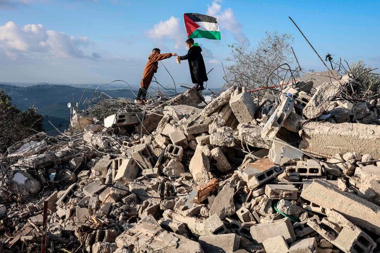 I landsbyen Bizariya på den israelsk besatte Vestbredden har et par børn taget opstilling på  resterne af et hus, der tilhørte en palæstinenser, som i sommer blev beskyldt for at have dræbt en israelsk bosætter og derpå dræbt. 
 Foto: Zain Jaafar/Ritzau Scanpix