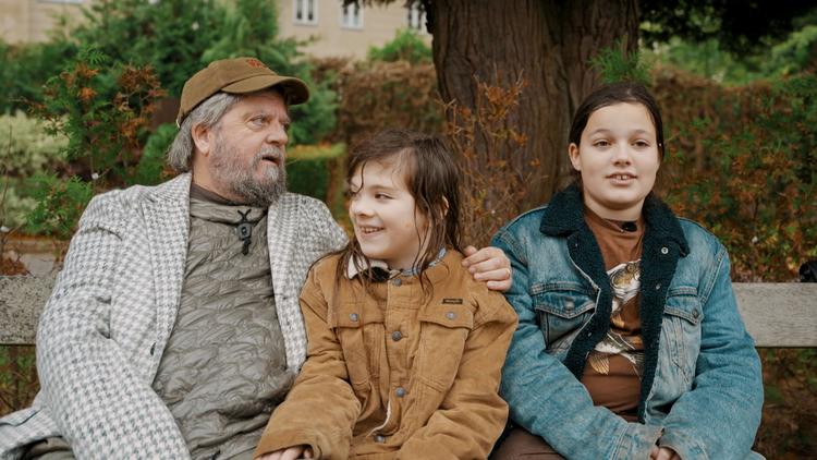 Anders Lund Madsen får sig en rørende snak om Gud og døden med sønnerne Stærk og Modig på kirkegården. Foto: Laud People 