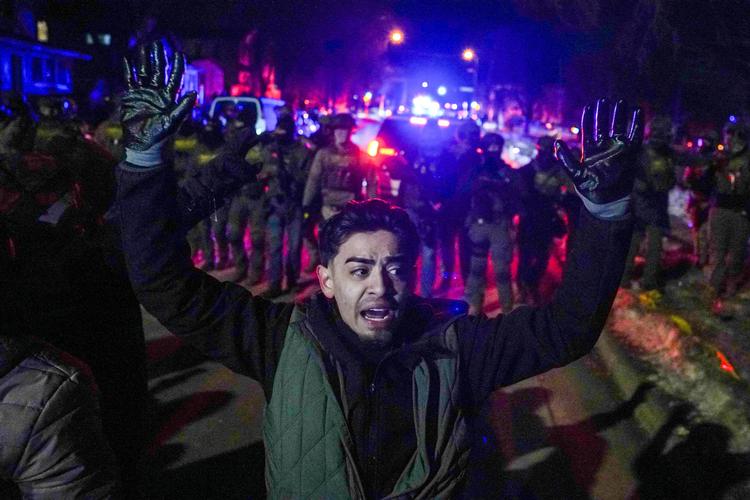 En mand holderne hænderne i vejret foran føderale agenter, da spændingerne stiger efter at føderale politibetjente var involveret i en skudepisode, en uge efter at en agent fra det amerikanske immigrations- og toldvæsen (ICE) skød Renee Nicole Good ihjel i det nordlige Minneapolis, Minnesota, USA, den 14. januar 2026  Foto: Ryan Murphy/Ritzau Scanpix