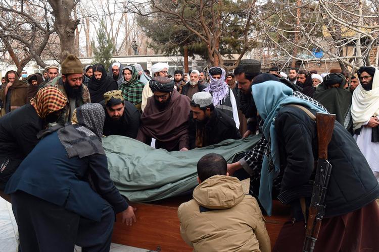 Taliban-medlemmer bærer den indhyllede krop af en kinesisk mand, der døde i eksplosionen i den kinesiske restaurant i Kabul. Foto: Bais Yusufi/Ritzau Scanpix