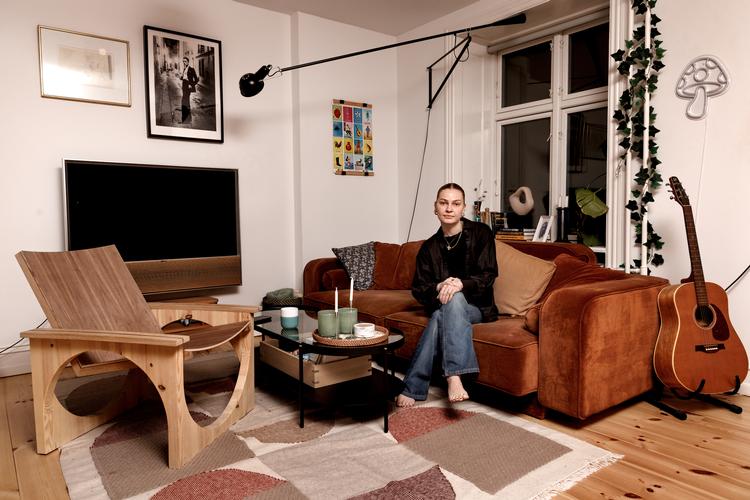 25-årige Sarah Haagendrup i sin og kærestens lejlighed på Frederiksberg. Til venstre ses den stol, hun for nylig selv har designet som en del af møbelsnedkeruddannelsen.  Foto: Jacob Ehrbahn