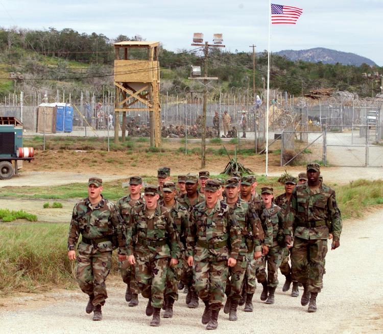 Amerikanske soldater marcherer foran Camp X-Ray, den kontroversielle militærbase i Cuba. 9. januar 2002. Foto: Joe Skipper/Ritzau Scanpix