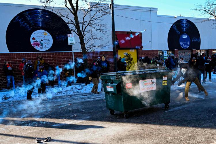 Tåregas flyver gennem luften, mens demonstranter samler sig på stedet, hvor en mand  skal være blevet skudt i Minnesota. Foto: Roberto Schmidt/Ritzau Scanpix